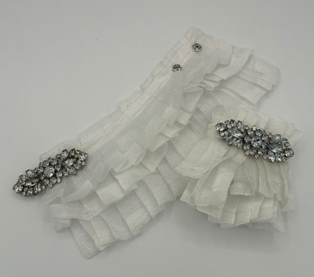 White ruffled organza wrist cuff with two silver rhinestone embellishments on a plain light gray background.