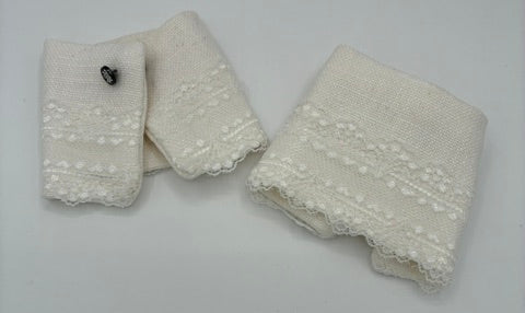 white colored lace cuffs with scalloped edges and embroidered floral details, arranged on a plain light gray background.