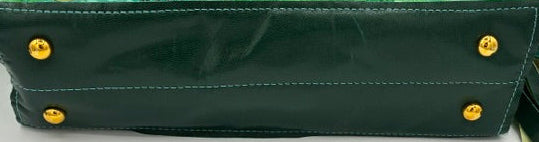 A green handbag shown from the bottom corner, featuring a glossy dark green leather base with gold-tone rivets and a patterned green and beige fabric body with a matching strap.