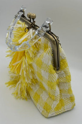 A small yellow and white checkered  purse with a clear plastic frame and a yellow feather accent, shown on a plain white background.